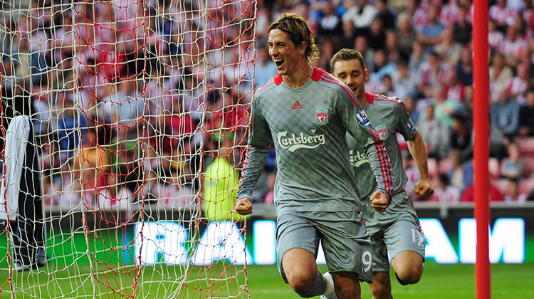 Torres celebrates a goal wearing grey Liverpool kit