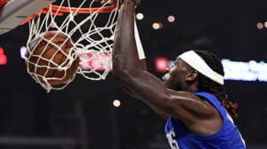 NBA player slam dunks the ball