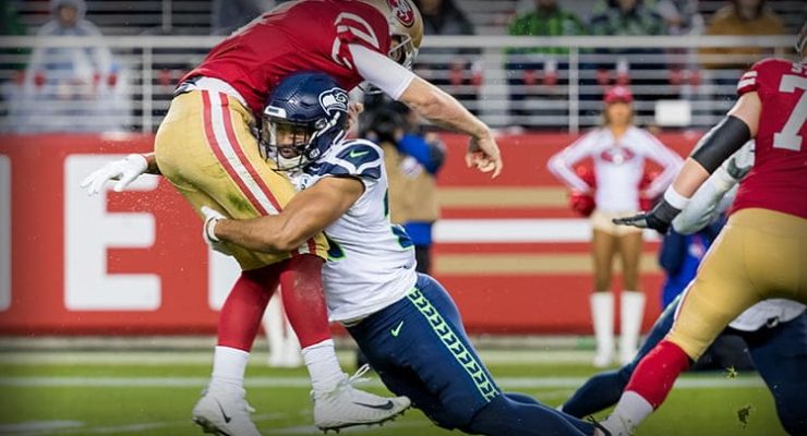 49ers NFL player is tackled by Seattle Seahawk