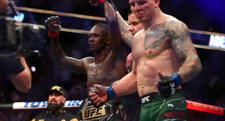 Israel Adesanya has his hand raised in victory after a UFC fight.